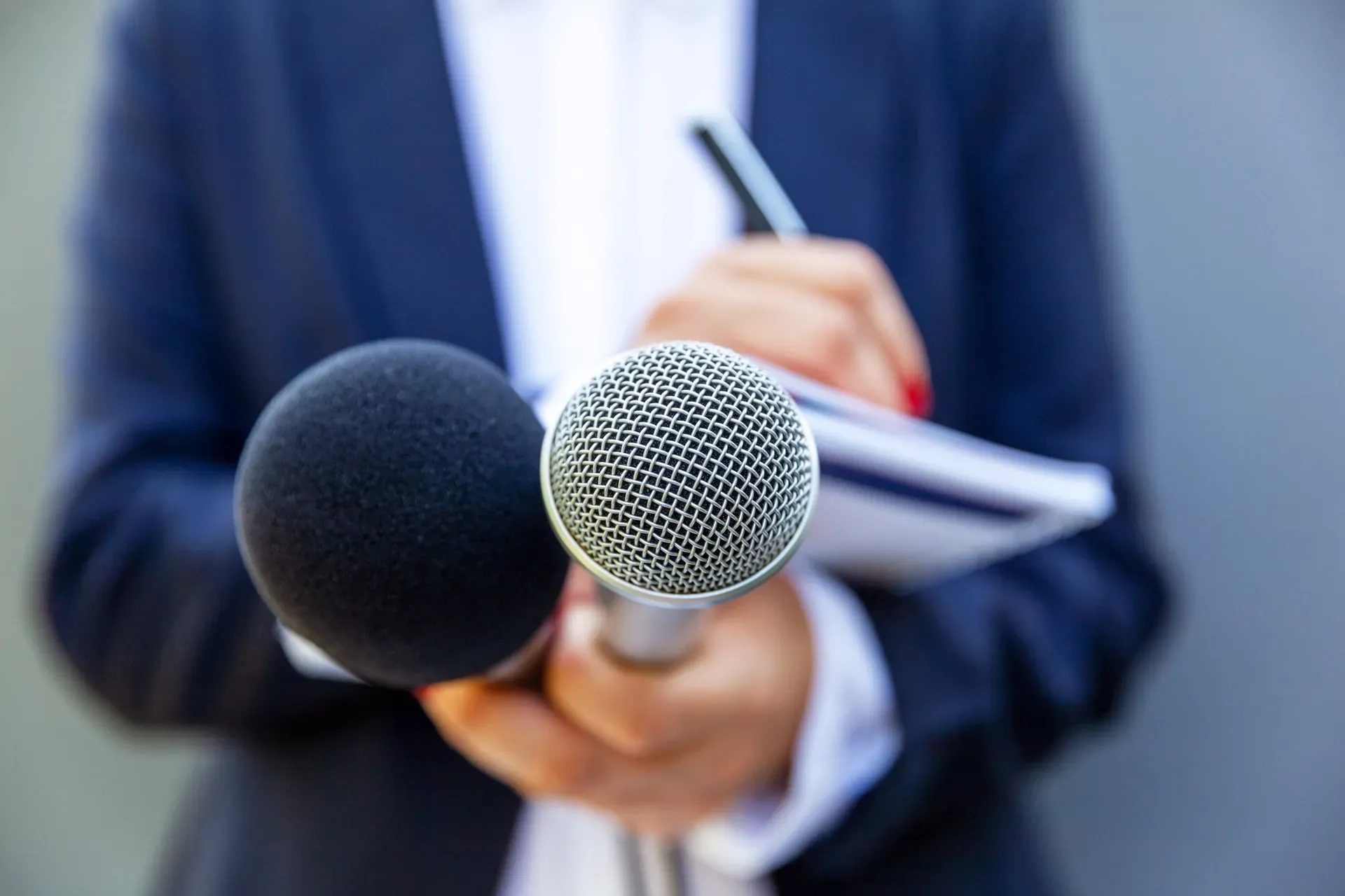 A reporter's microphone held out at a press interview